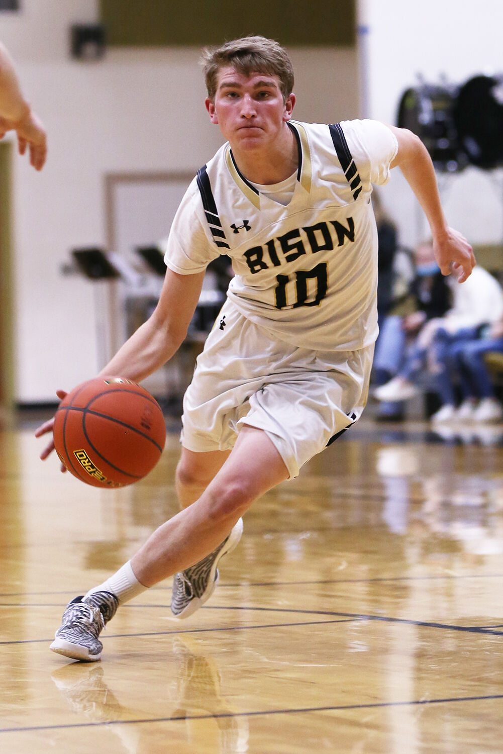 Taylor Swanston scans for a teammate as he dribbles toward the basket
